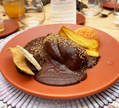 El platillo se acompaña tradicionalmente de guajolote (pavo), símbolo de hospitalidad y abundancia.